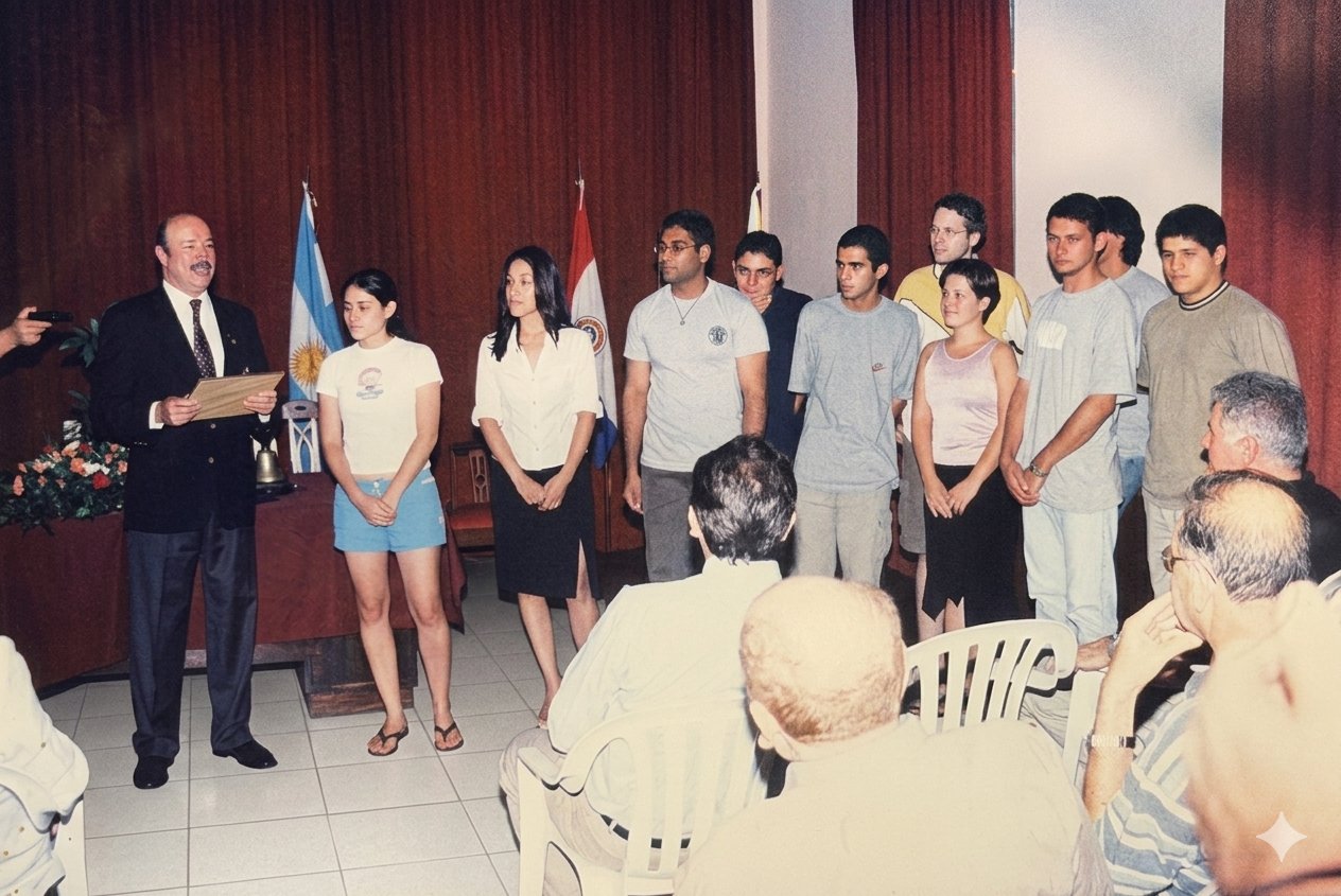 Rotaract Club Villarrica founding ceremony — senior Rotary official reading the charter with founding members lined up, flags and Rotary bell on display