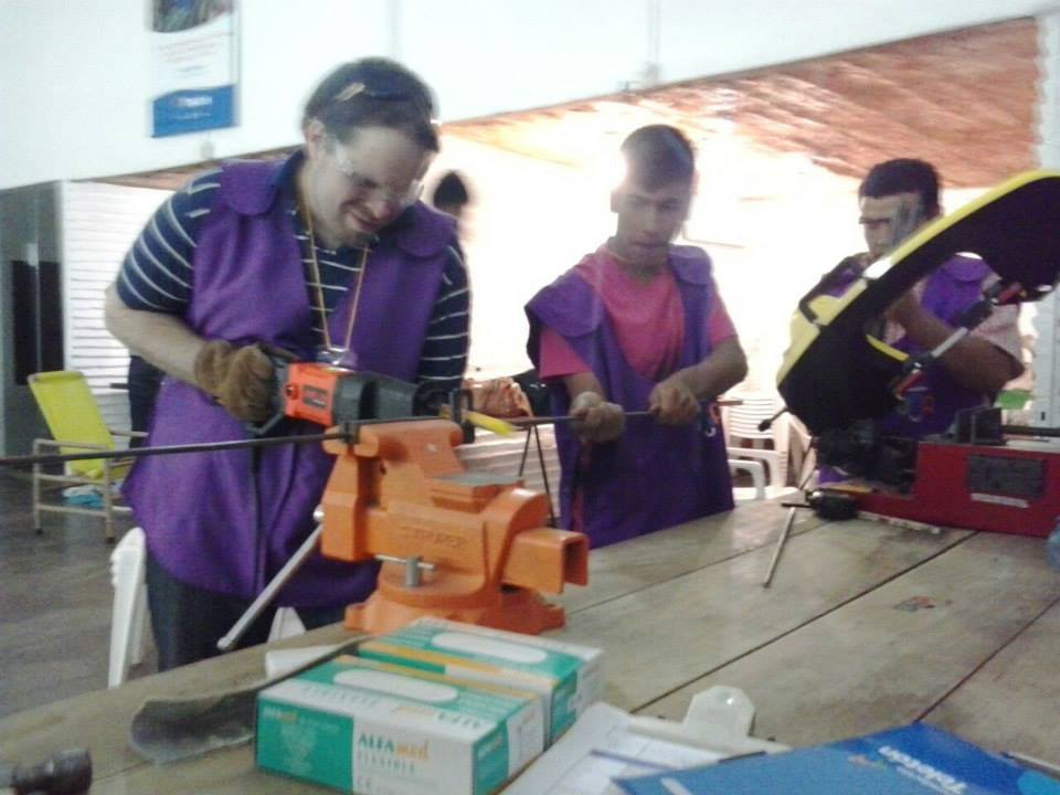 Christian working with tools at a Teletón home makeover project, wearing the purple volunteer vest